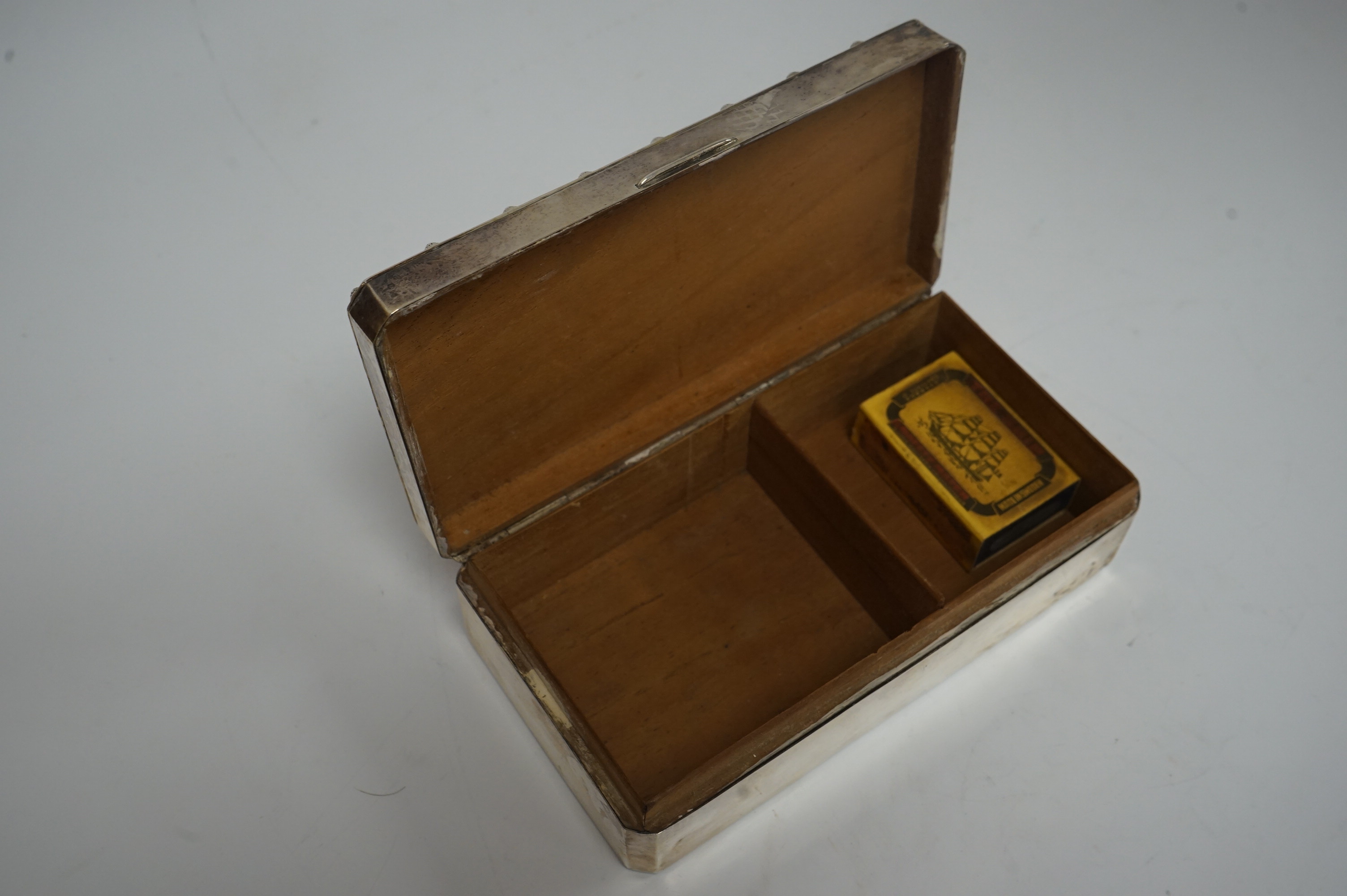 A George V silver mounted rectangular cigarette box, by Harrods Ltd, Birmingham, 1935, 16.6cm. Condition - poor to fair